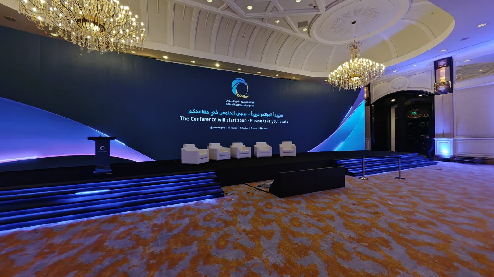 Conference stage under chandeliers at the National Cyber Security Agency conference